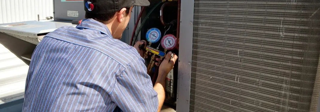 HVAC technician servicing a condenser unit in Dade City